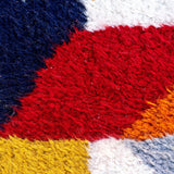 Jovial Moroccan Rug, a blue, red, and tangerine on natural white wool, showcasing the eclectic style of Berber women