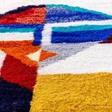 Jovial Moroccan Rug, a blue, red, and tangerine on natural white wool, showcasing the eclectic style of Berber women