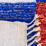 Jovial Moroccan Rug, a blue, red, and tangerine on natural white wool, showcasing the eclectic style of Berber women
